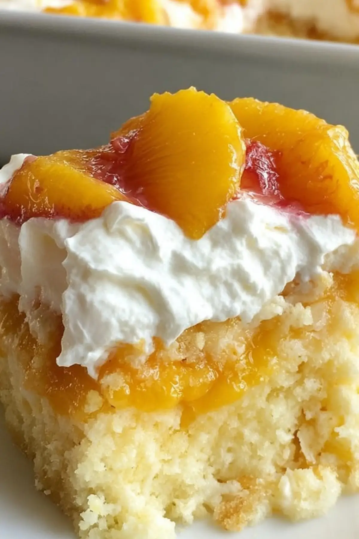 Peaches and Cream Poke Cake with fresh peach topping