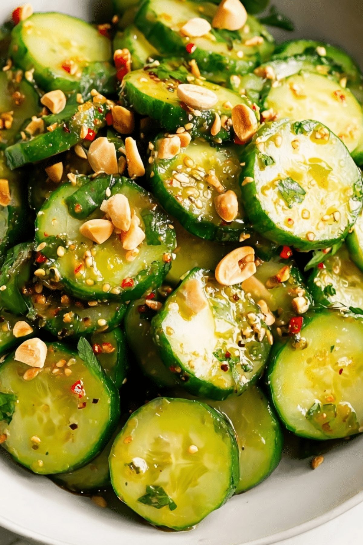 Asian cucumber salad with peanuts and sesame seeds in bowl