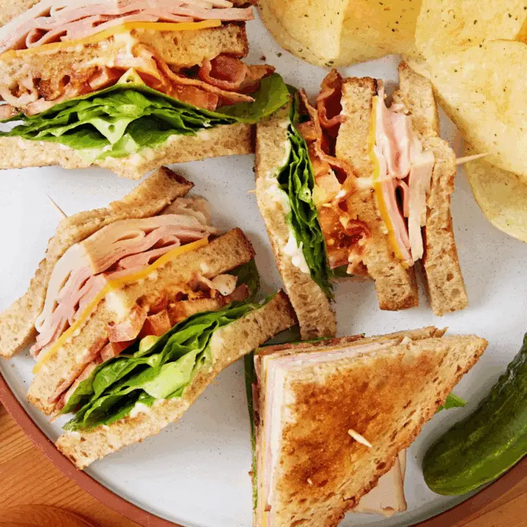 Club sandwich recipe with bacon, turkey, and tomato stacked on toasted bread