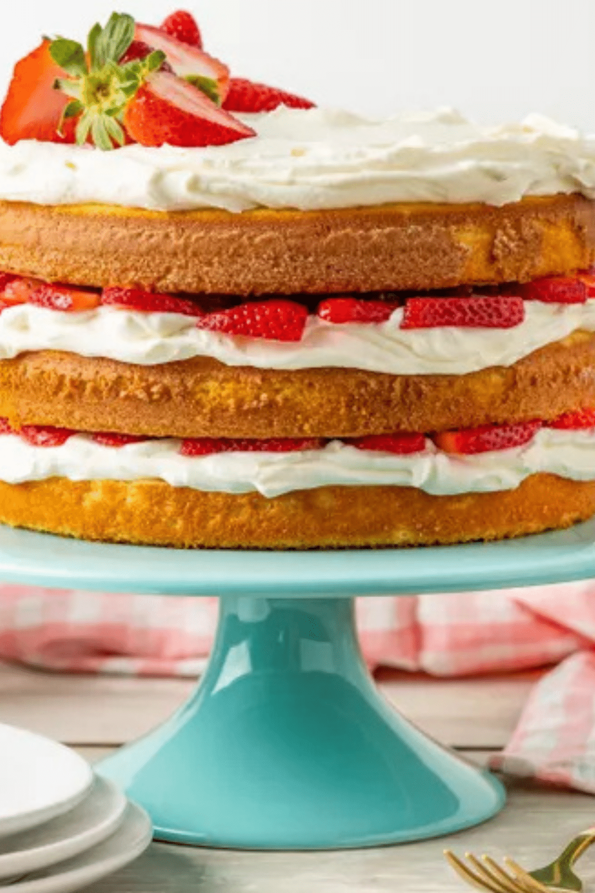 Layered Strawberry Shortcake Cake with whipped cream and fresh berries