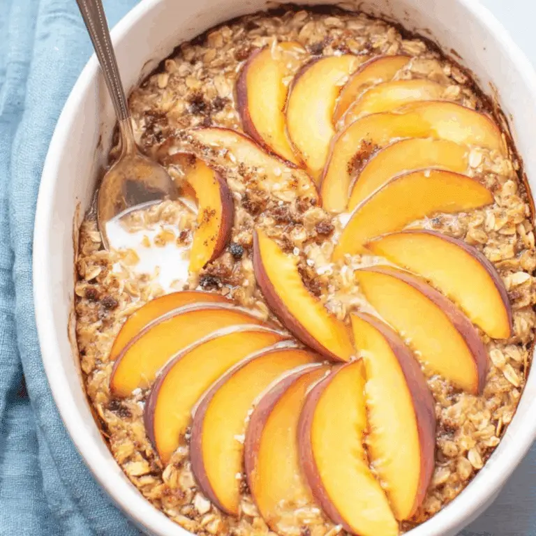 Peach Baked Oatmeal in baking dish with fresh peaches and pecans