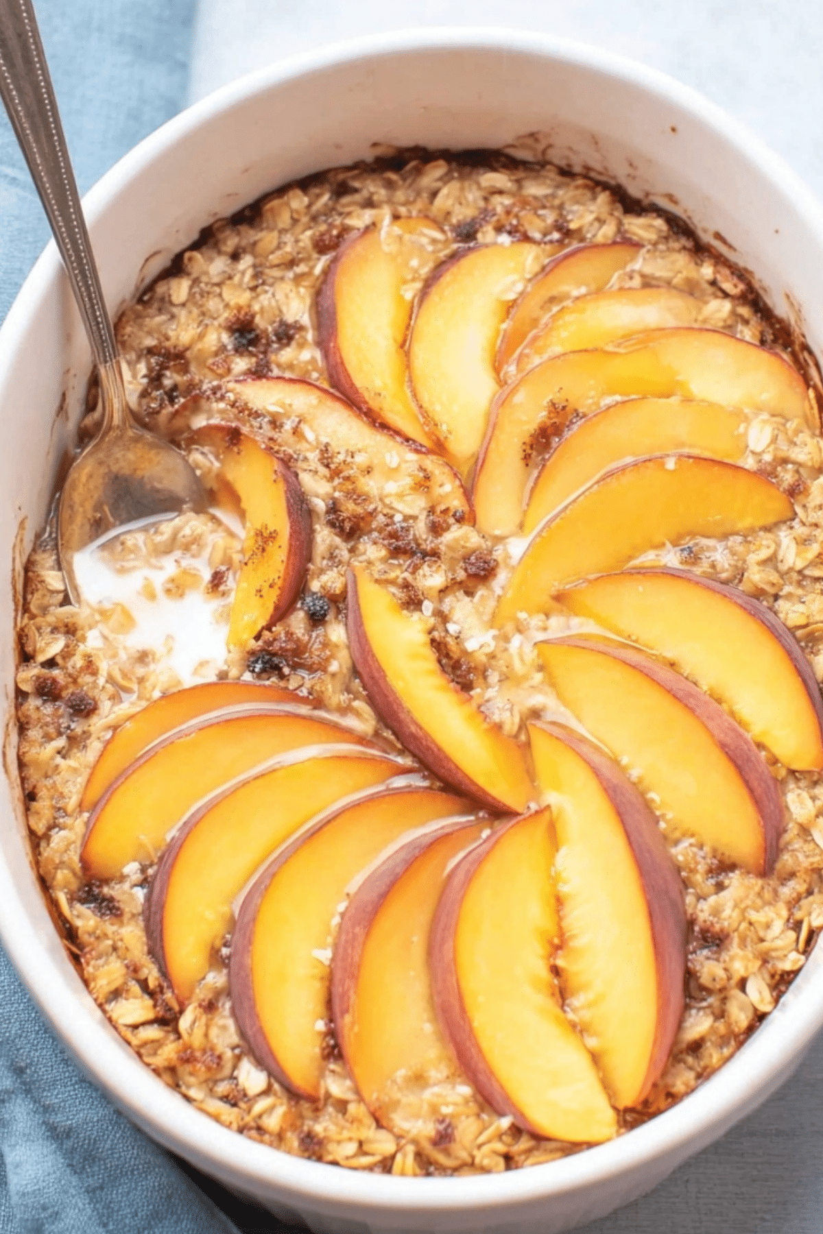 Peach Baked Oatmeal in baking dish with fresh peaches and pecans