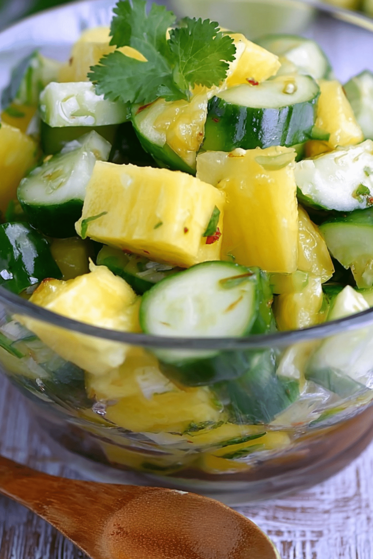 Fresh Pineapple Cucumber Salad in a white bowl with lime and cilantro