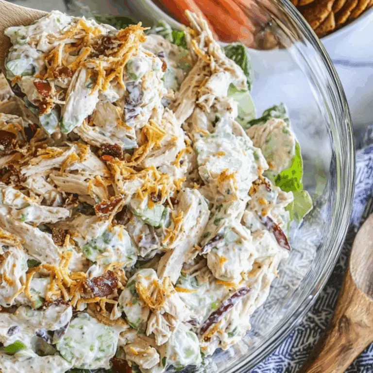 Million Dollar Chicken Salad served in a bowl with bacon, cheddar, and fresh veggies