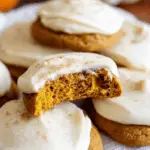 Pumpkin cookies with cream cheese frosting topped with cinnamon
