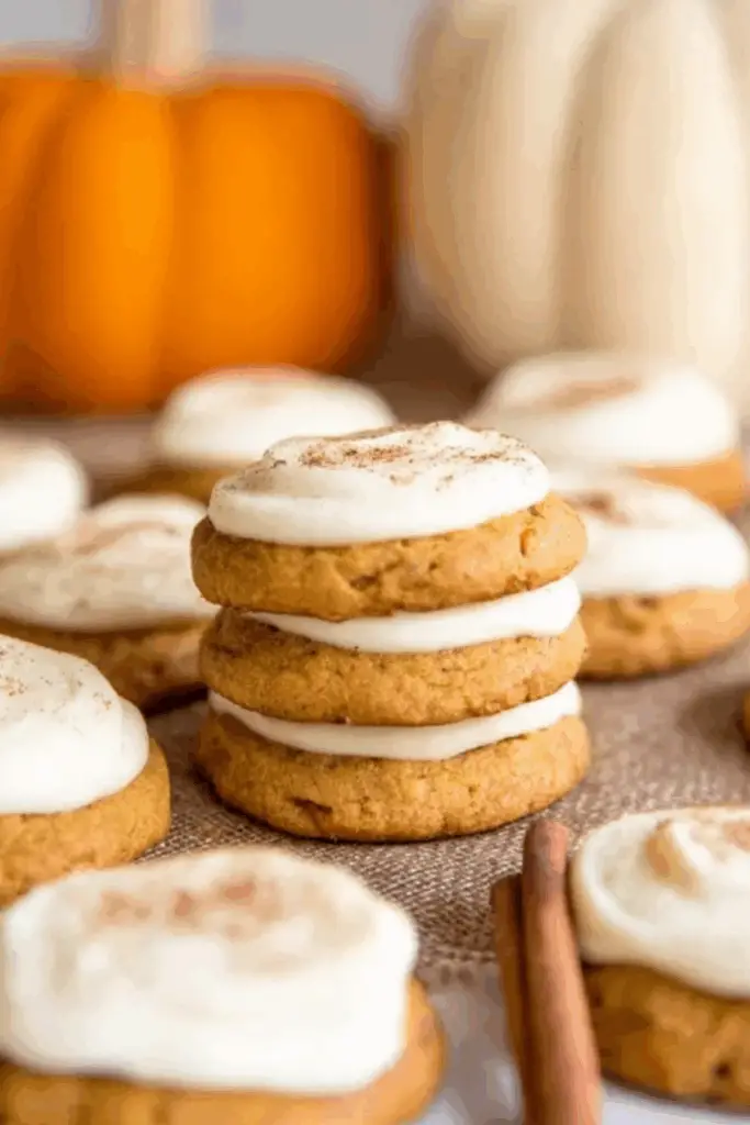 Pumpkin cookies with cream cheese frosting topped with cinnamon