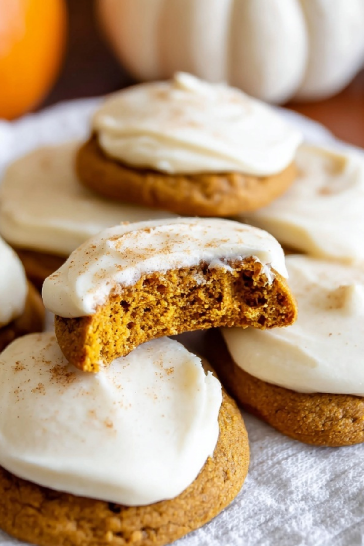 Pumpkin cookies with cream cheese frosting topped with cinnamon