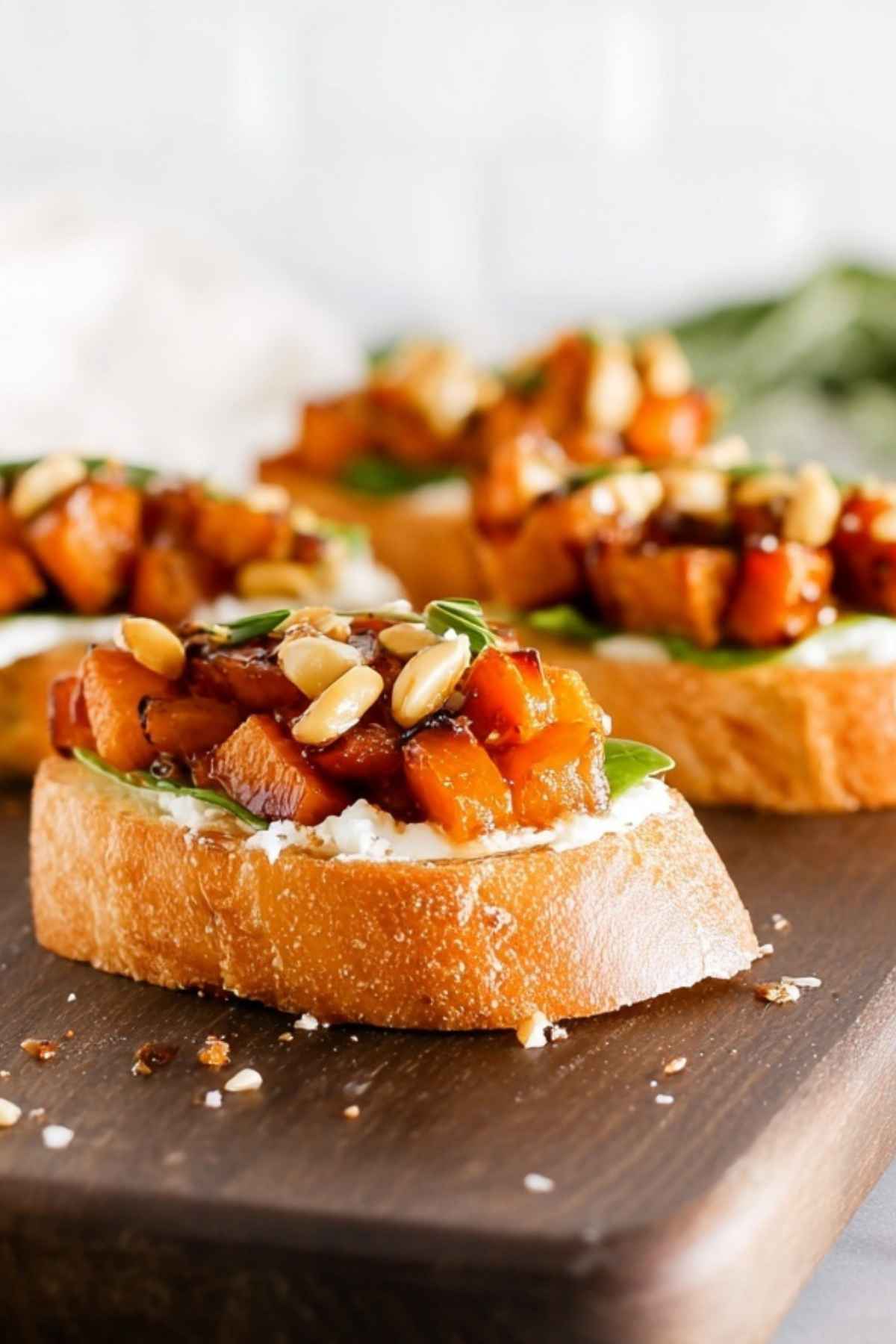 Whipped Goat Cheese Butternut Squash Bruschetta served on toasted baguette with arugula, honey, and pumpkin seeds.