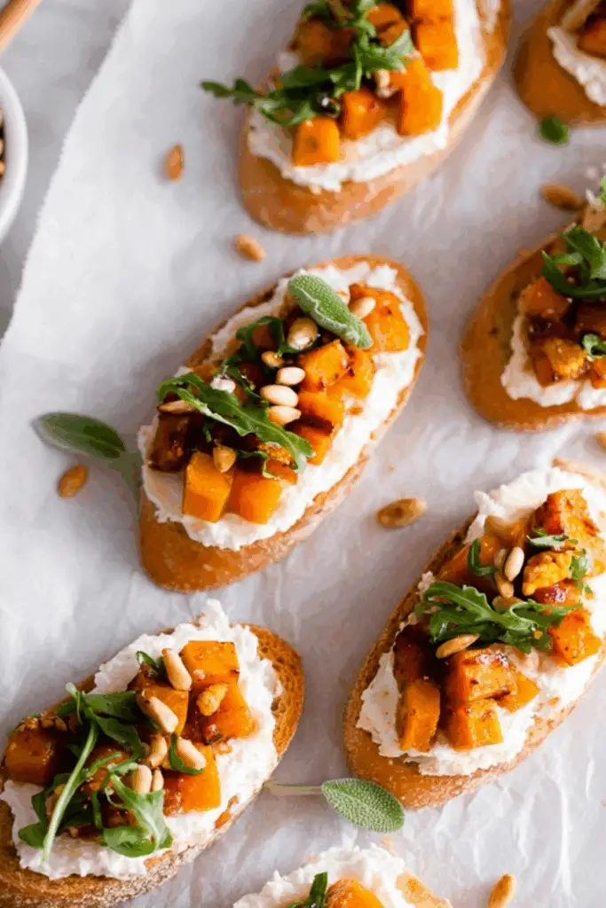 Whipped Goat Cheese Butternut Squash Bruschetta served on toasted baguette with arugula, honey, and pumpkin seeds.