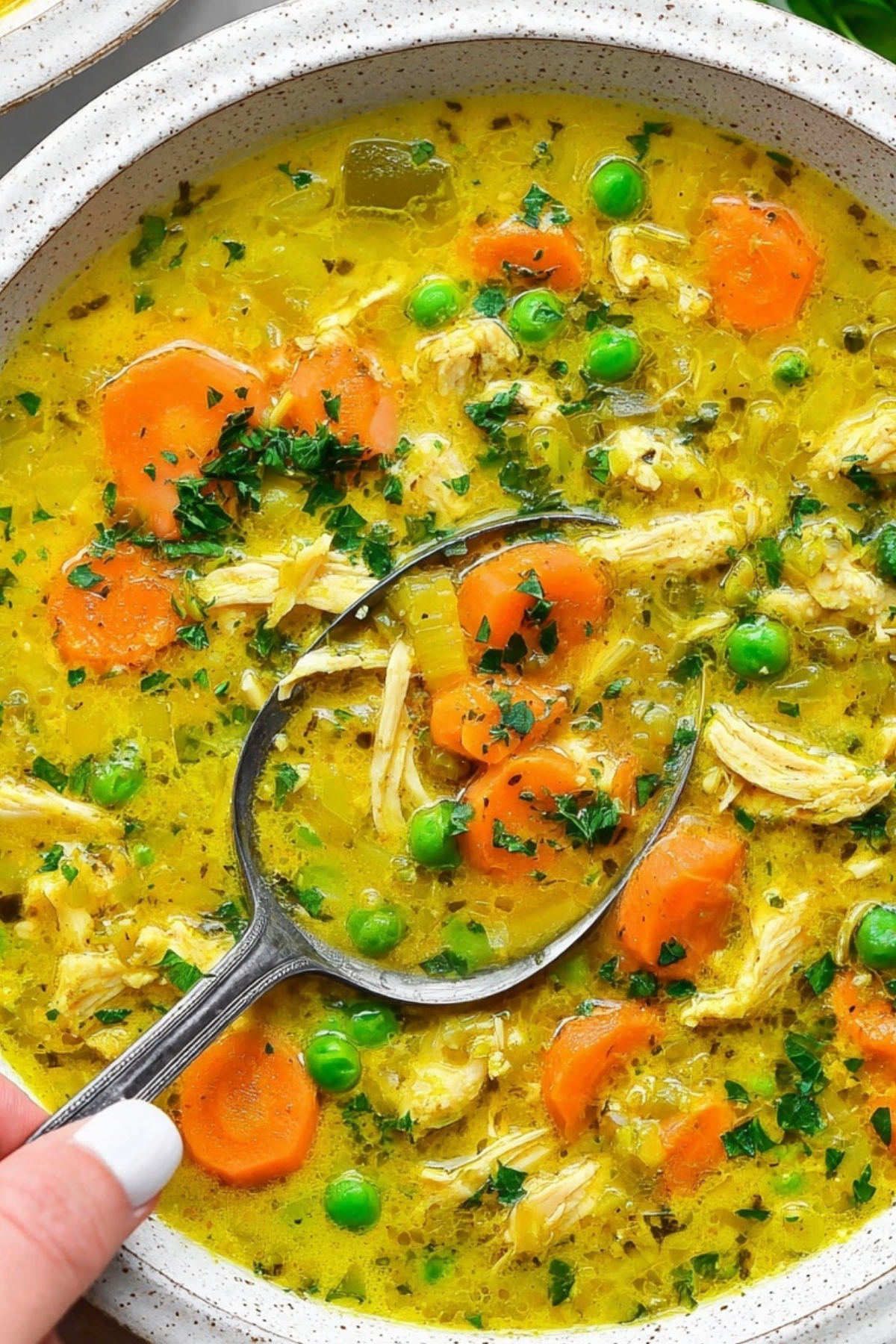 Anti Inflammatory Turmeric Chicken Soup in a bowl with fresh parsley