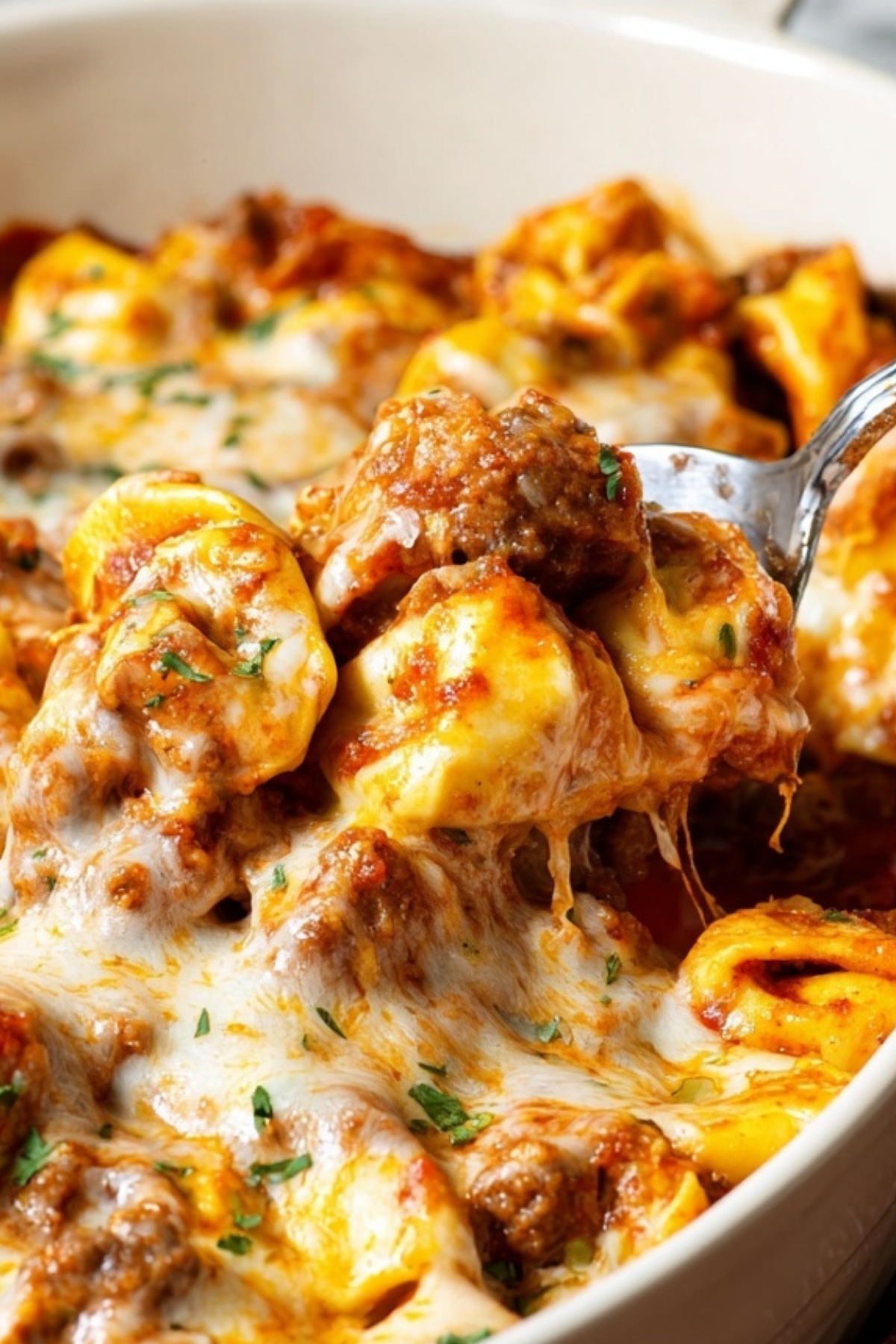 Cheesy baked tortellini in casserole dish with marinara and beef