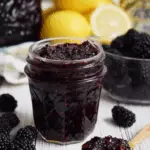Blackberry Vanilla Bourbon Jam in glass jar with spoon
