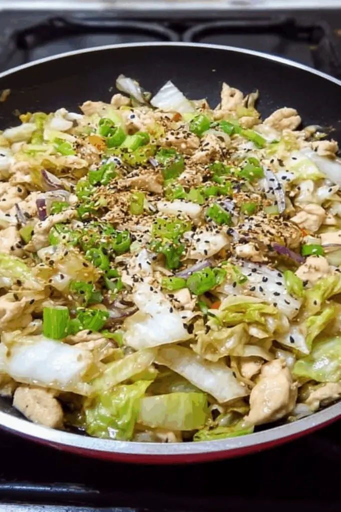 Chicken Cabbage Stir Fry in a skillet with vegetables and chicken strips