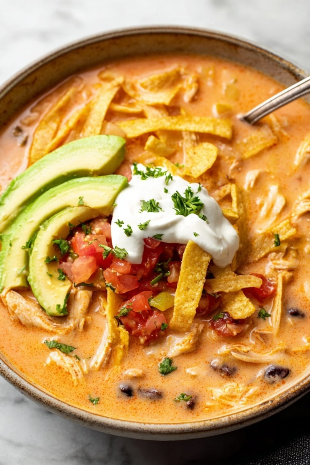 bowl of creamy chicken tortilla soup with toppings