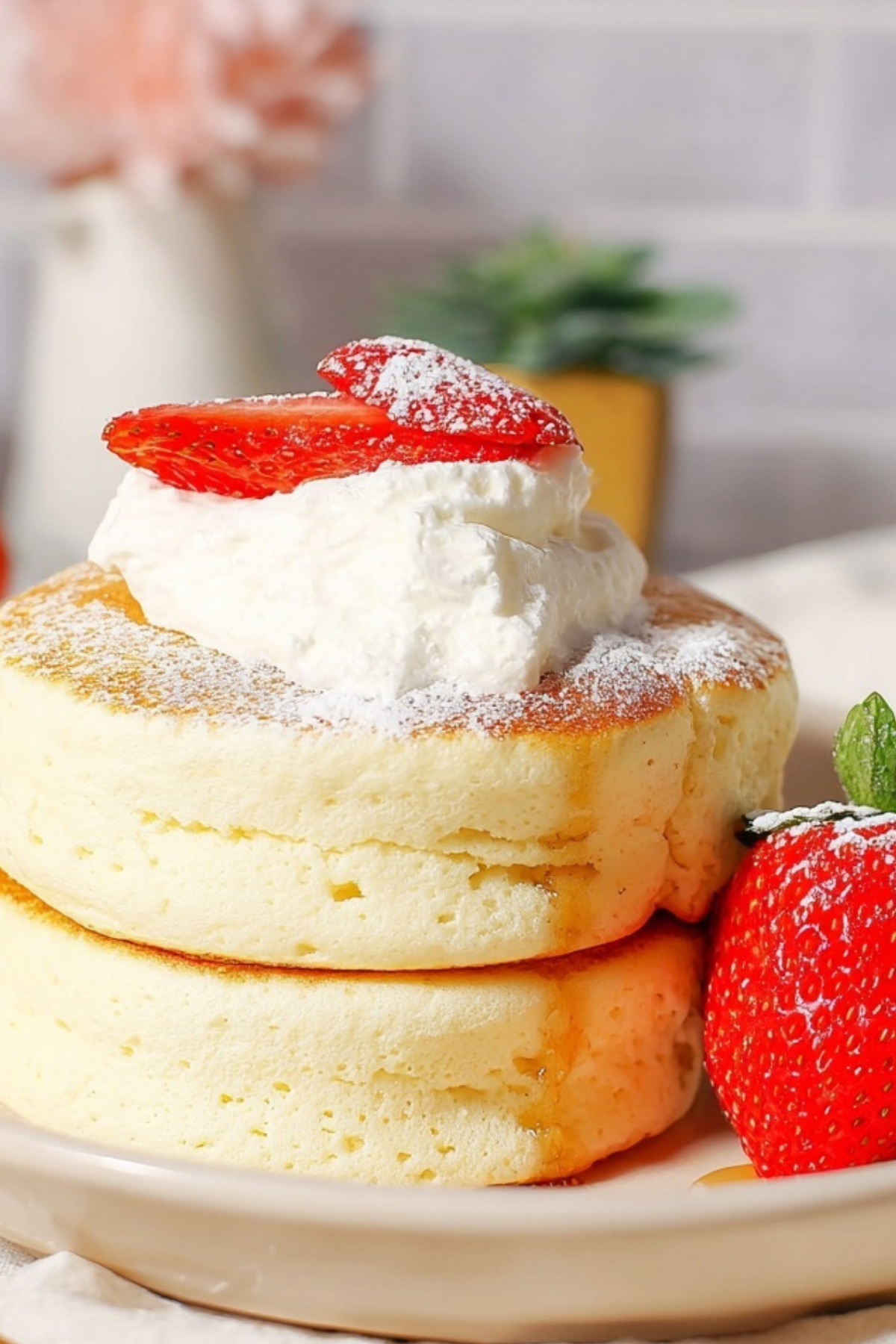 Fluffy Japanese Soufflé Pancakes stacked with whipped cream and fresh berries
