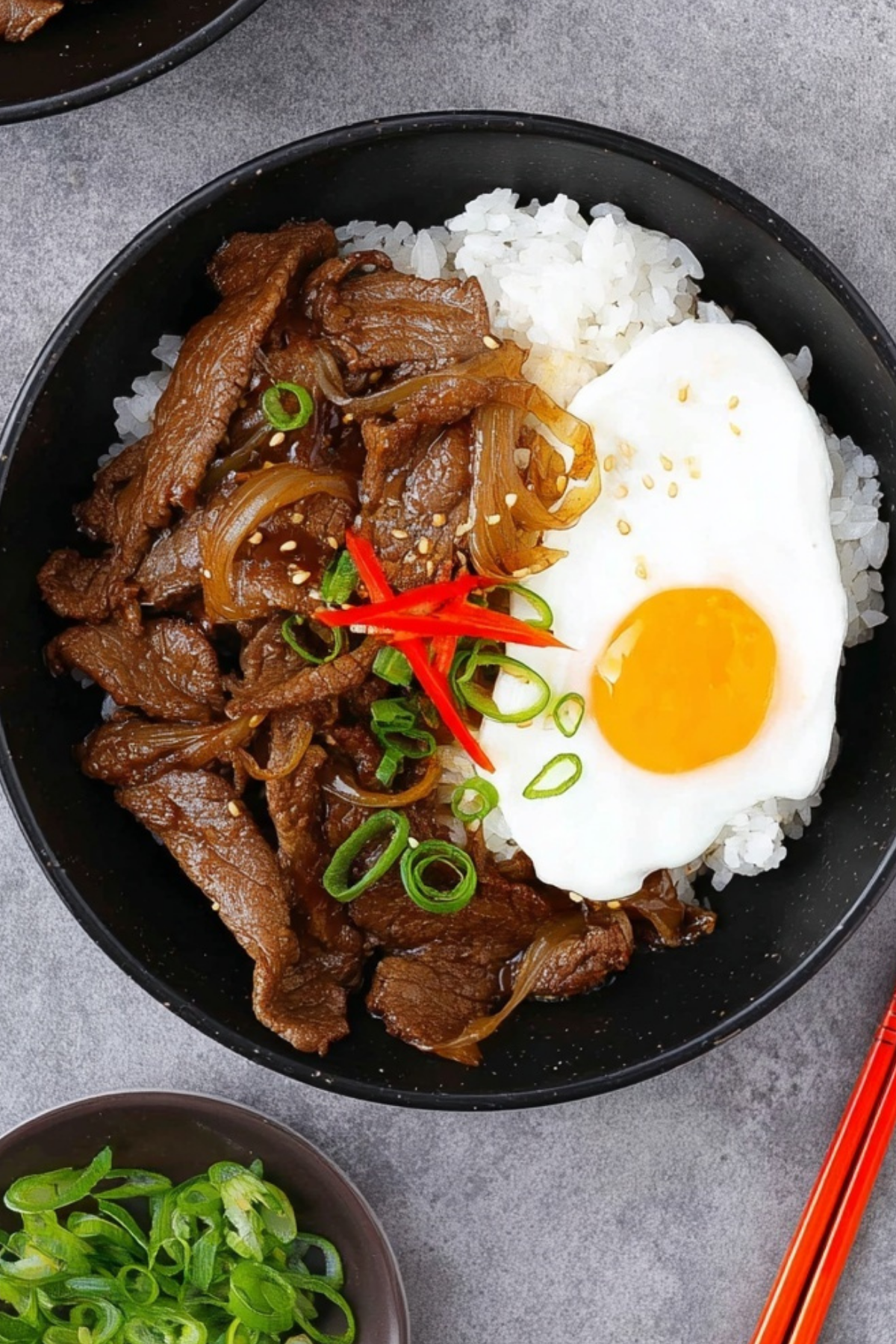Gyudon Japanese beef bowl with rice, onions, and poached egg
