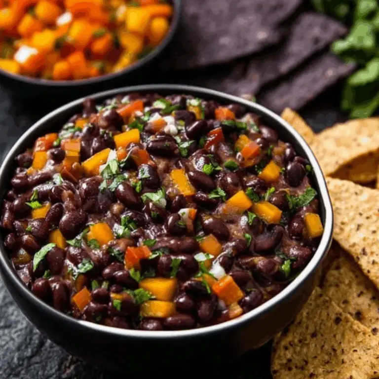 Halloween Bean Dip served with blue corn chips in black bowl