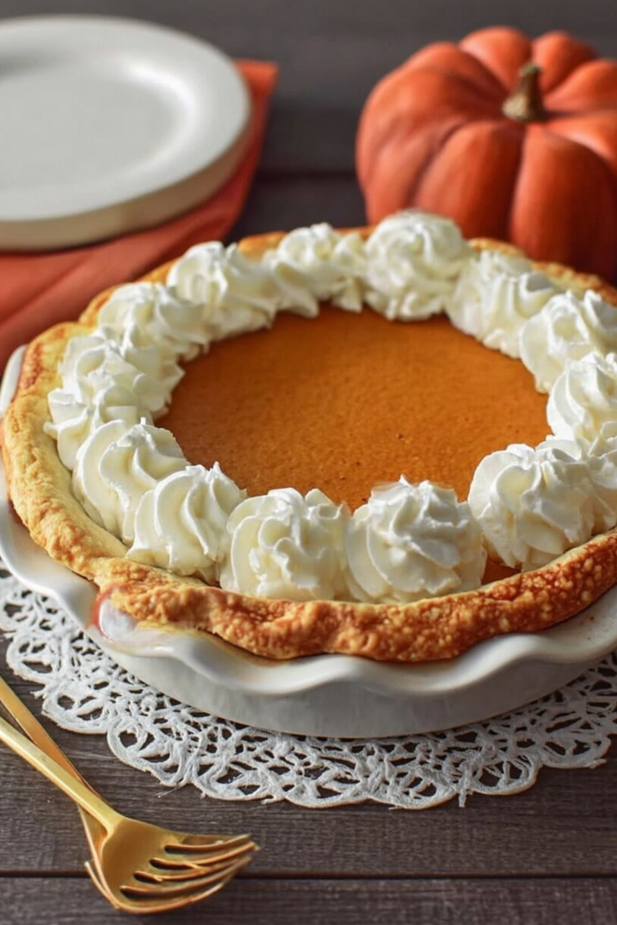 Creamy pumpkin pie with whipped cream in buttery crust