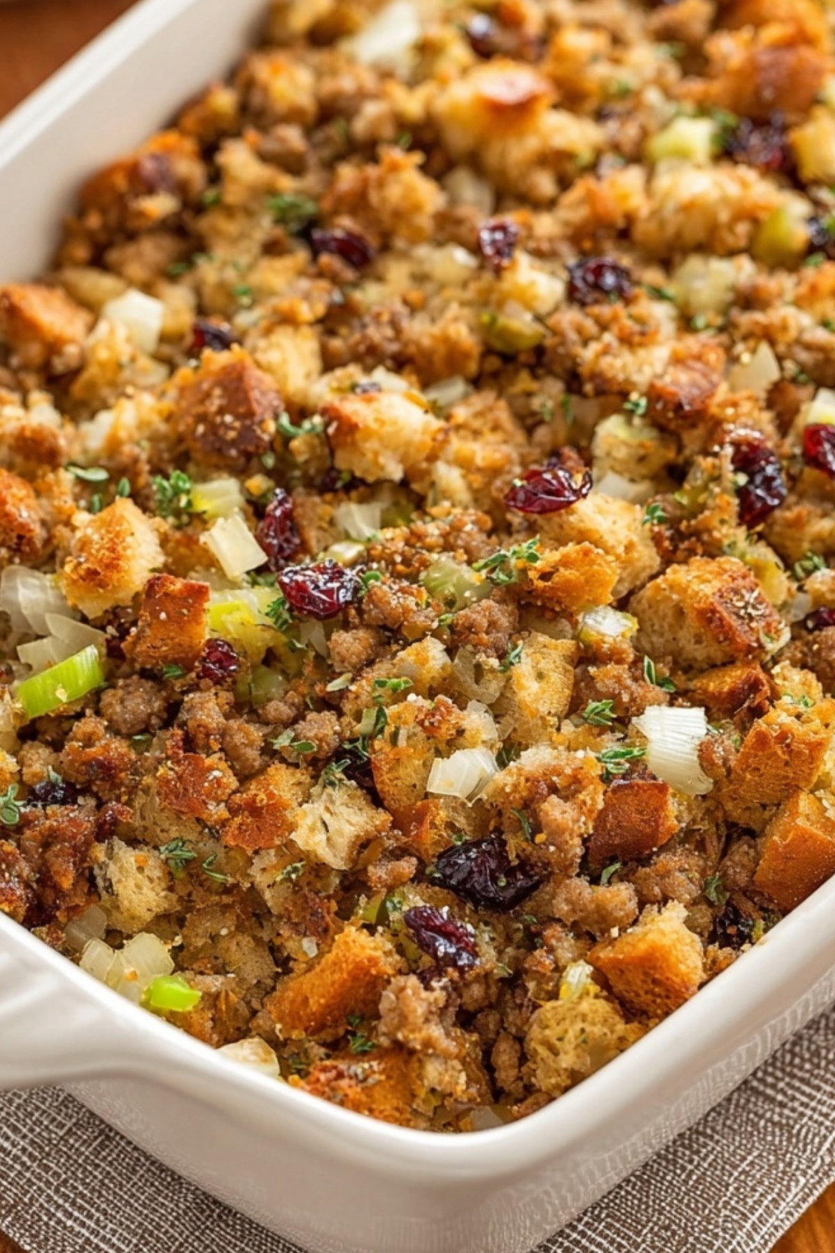 sausage stuffing with herbs and cranberries in casserole dish