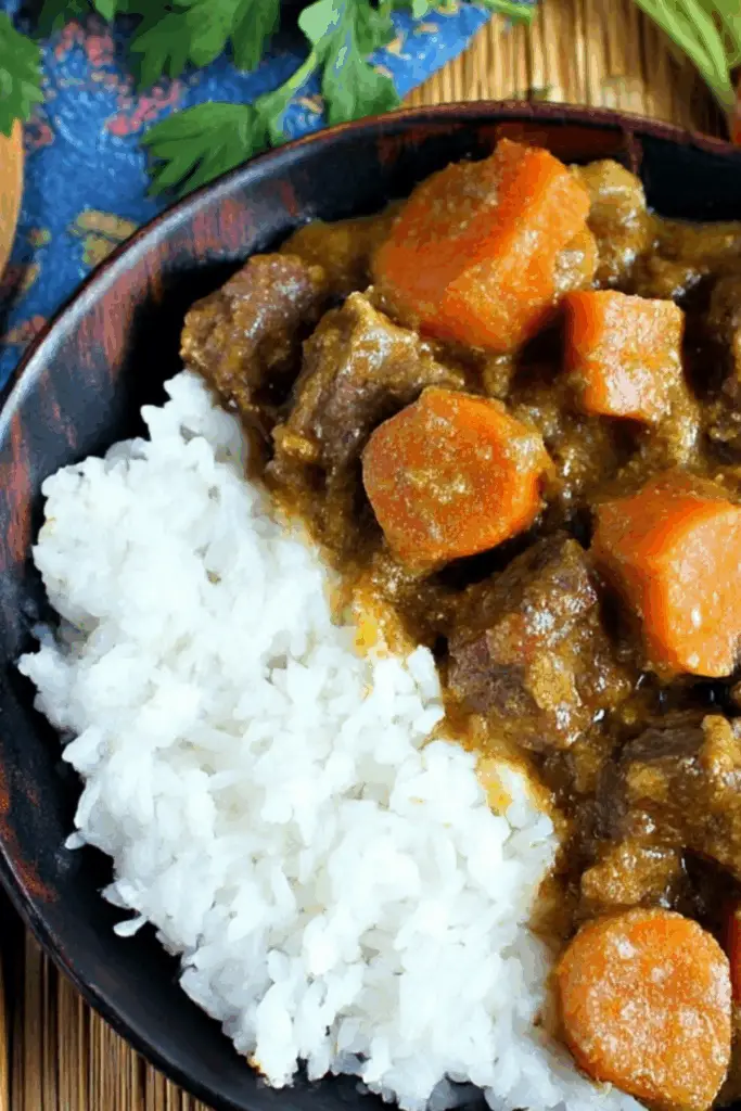 Slow cooker coconut curry beef stew in a bowl with rice