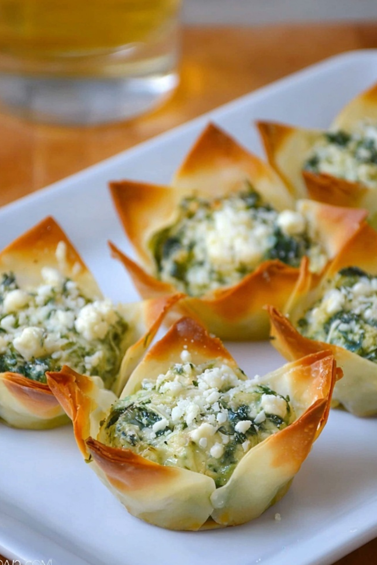 Spinach-Artichoke Dip Wonton Cups baked in muffin tin with creamy filling