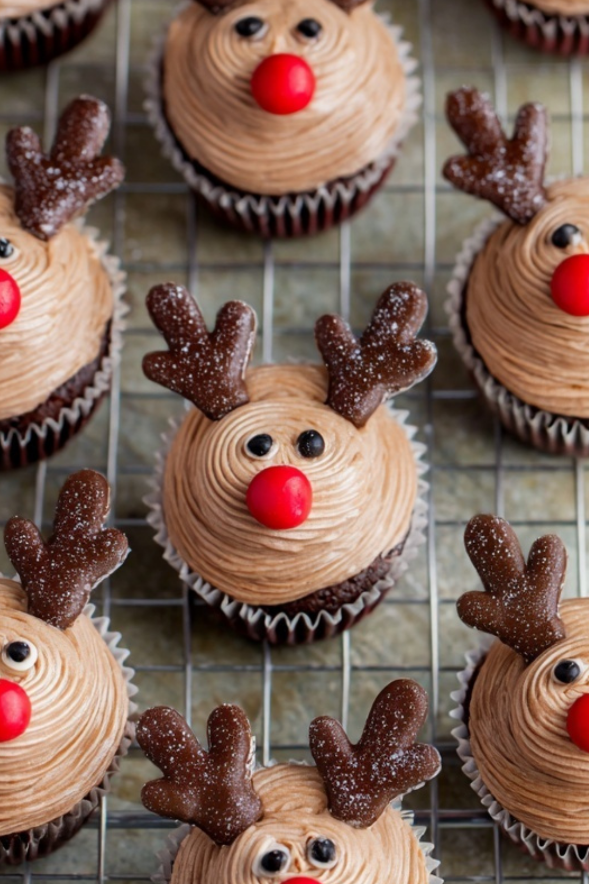 Reindeer cupcakes decorated with chocolate antlers and red icing nose