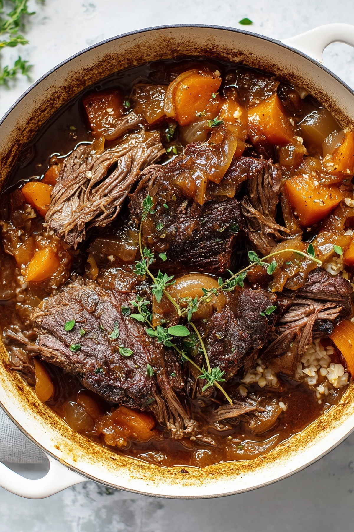 Cider braised pot roast with caramelized onions and cauliflower rice served in a rustic bowl