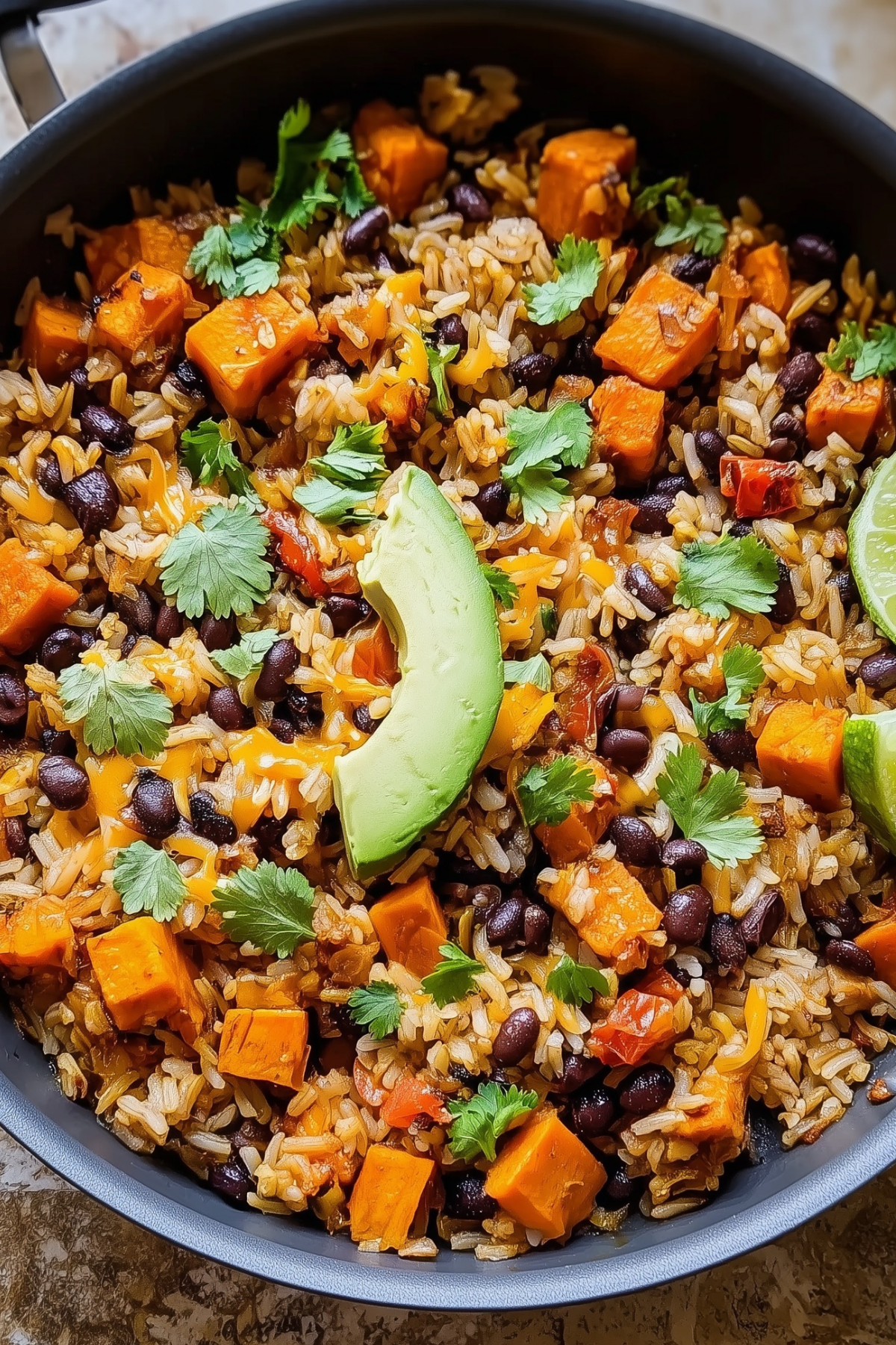 Southwest Sweet Potato, Black Bean, and Rice Skillet in a skillet, with colorful vegetables