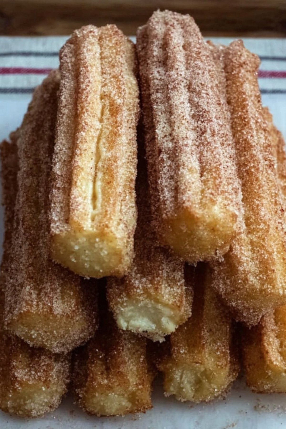 Baked churros coated in cinnamon sugar on a plate
