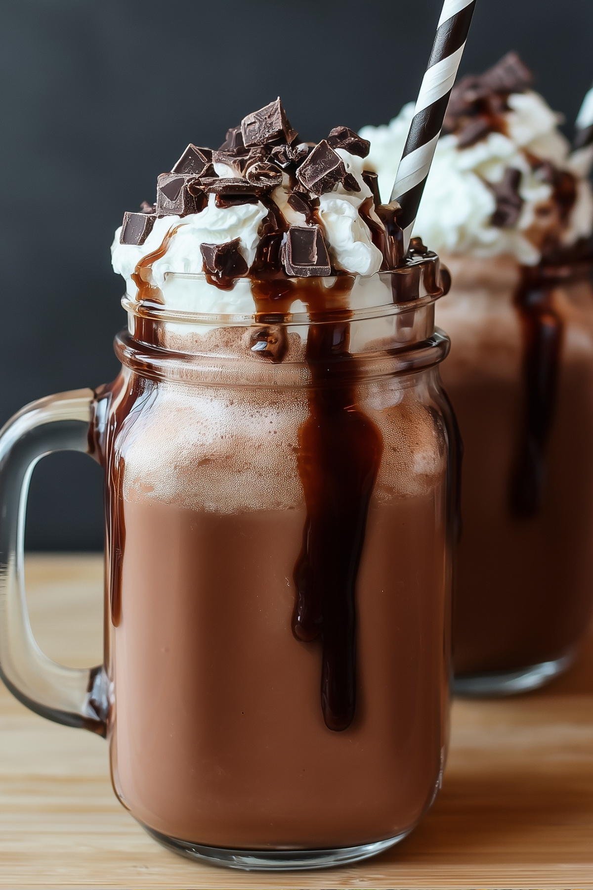 Glass of frozen hot chocolate topped with whipped cream and chocolate drizzle