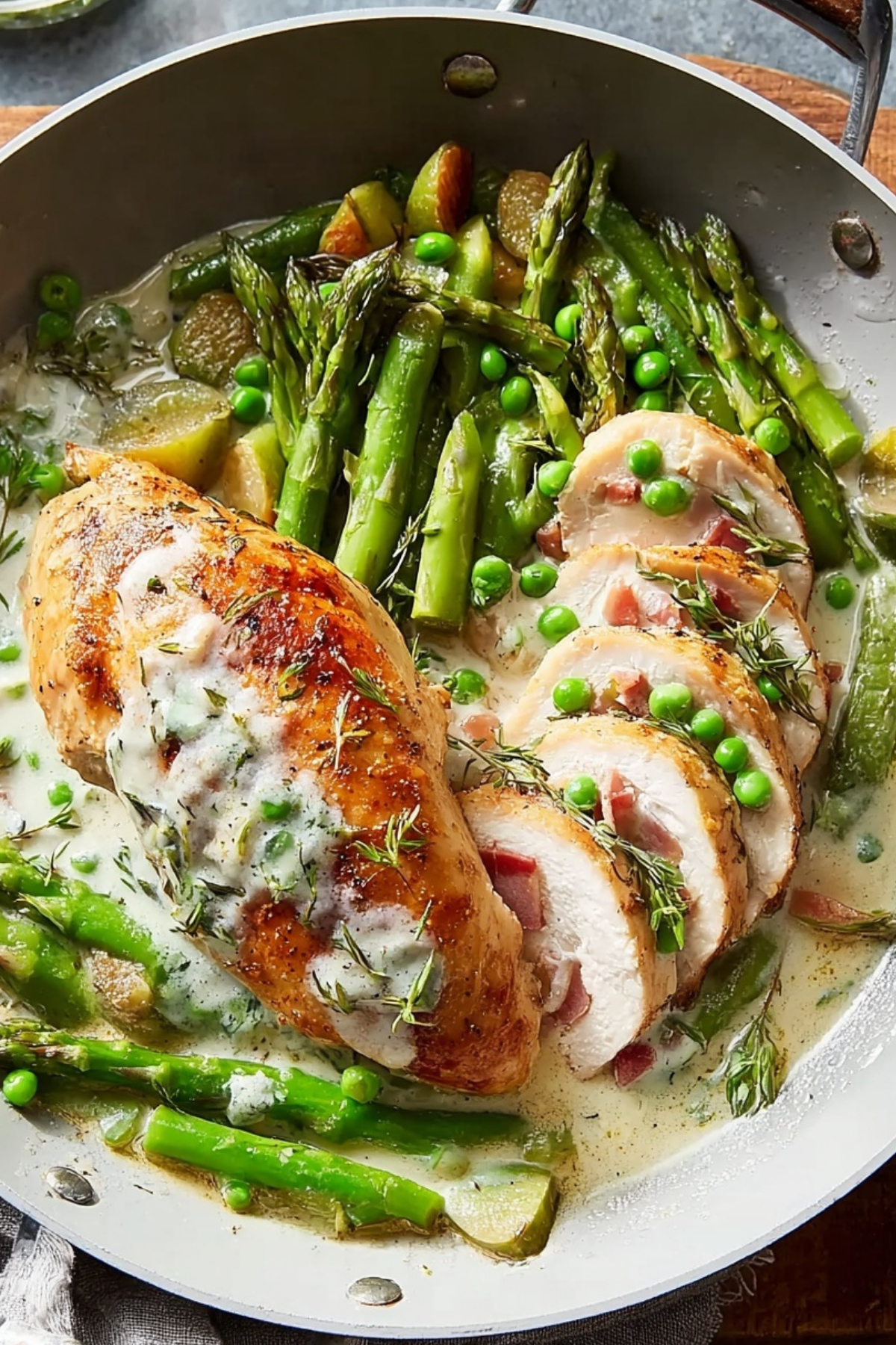 Fontina & Prosciutto Stuffed Chicken with Spring Vegetables in a skillet