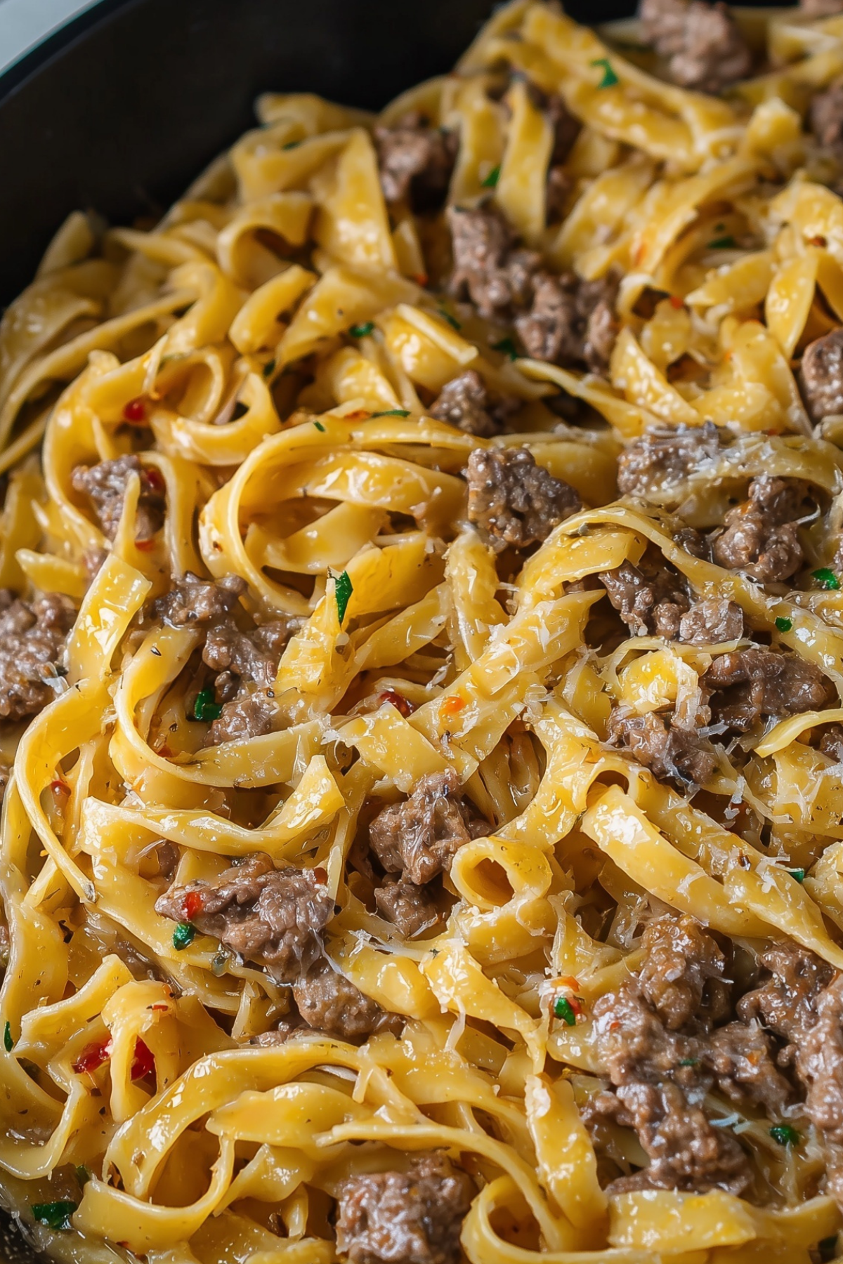 Garlic butter beef pasta served in a skillet with creamy sauce