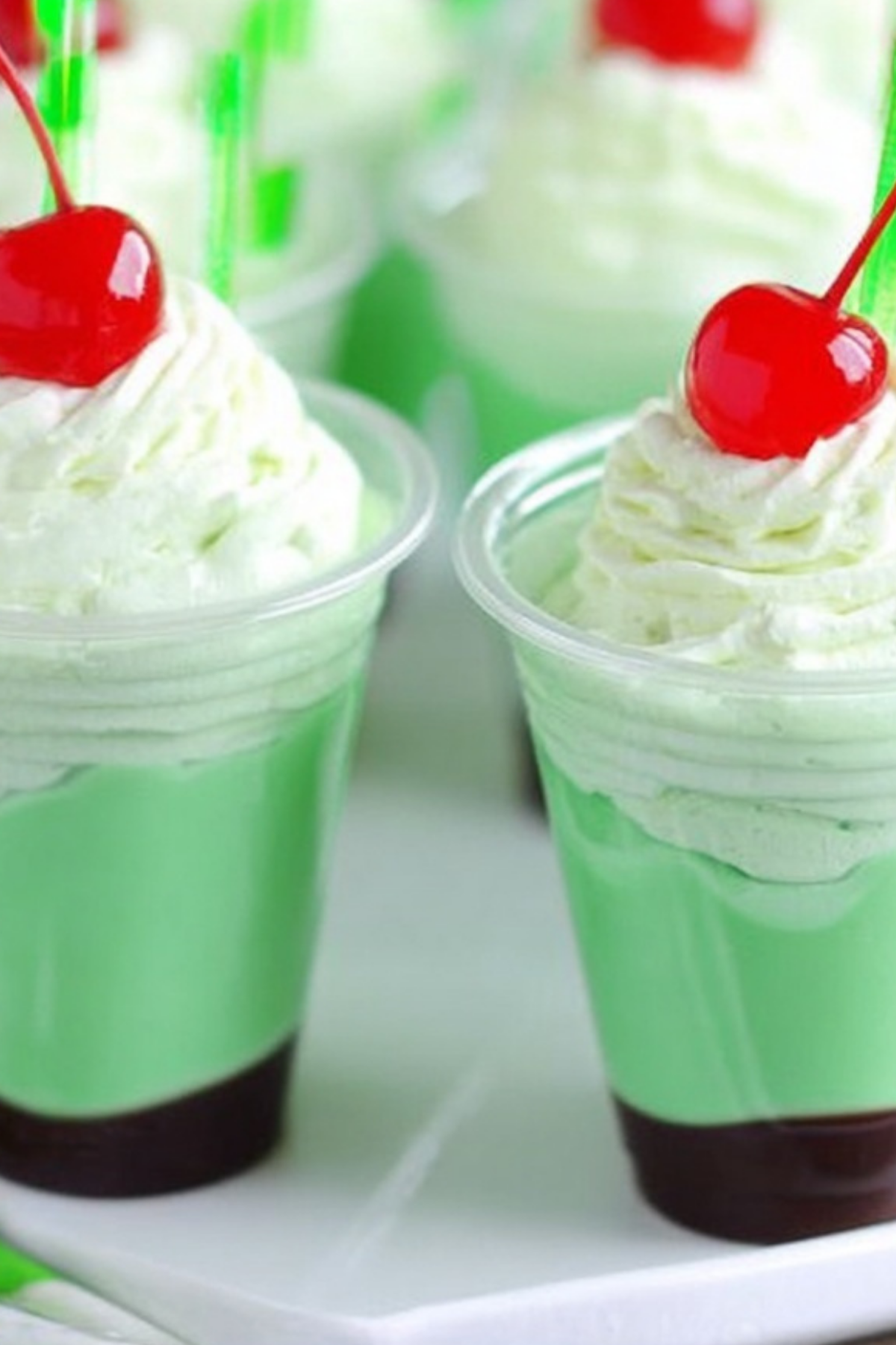 Shamrock Shake Pudding Shots topped with whipped cream and chocolate shavings