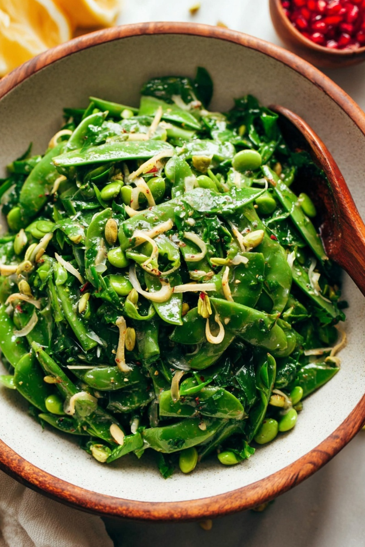 Snap Pea Salad with Zesty Lemon Vinaigrette in a white bowl with pistachios