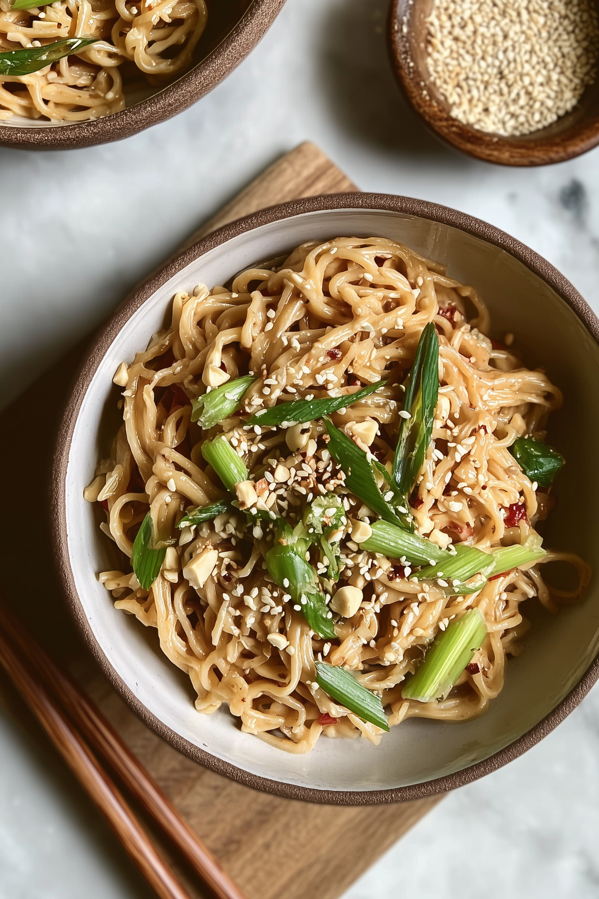 Cold sesame noodles with peanut and sesame sauce garnished with scallions