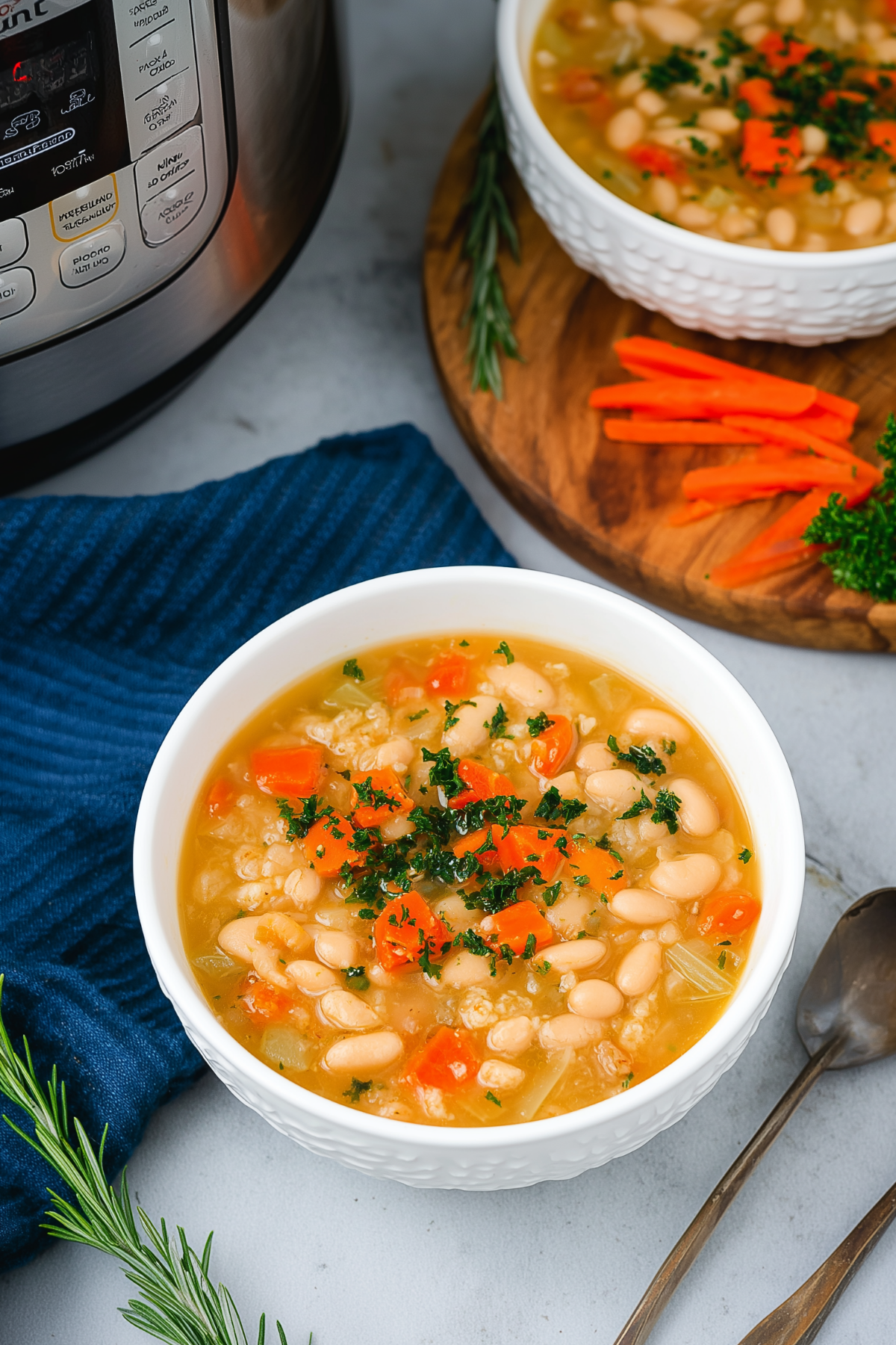 Instant Pot White Bean Soup in a bowl with fresh rosemary