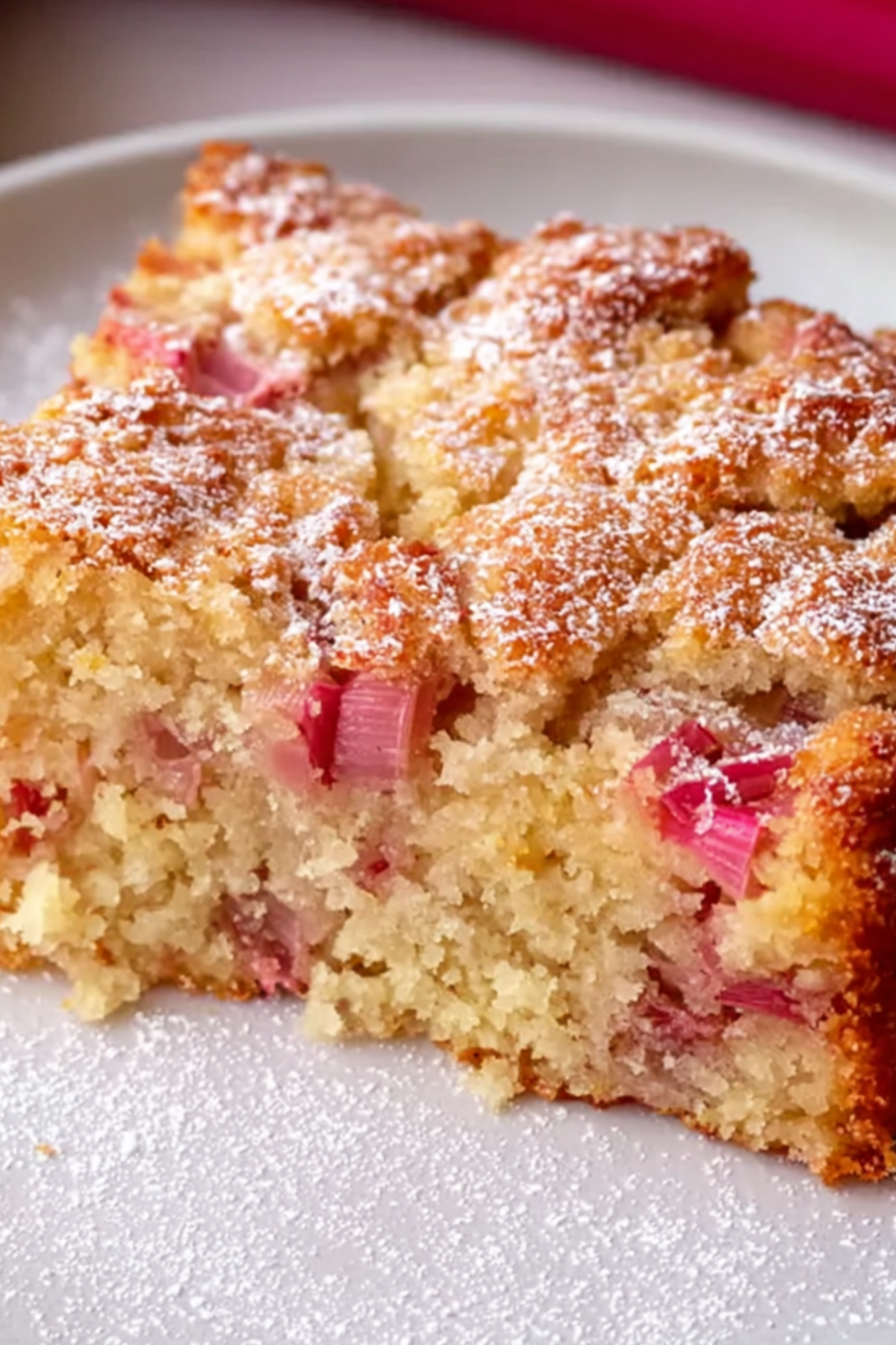 Slice of Moist Rhubarb Cake showing tender crumb and fresh rhubarb topping